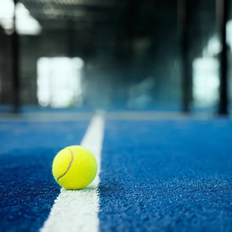 Padel rackets and balls on a blue court